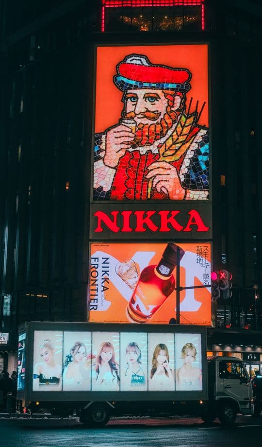 Neon billboard ad in the city at night