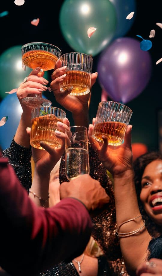 Guests toasting with cocktails and confetti